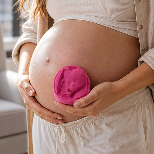 A photo of an expectant mother holding a 3D printed ultrasound keepsake against her pregnant belly.